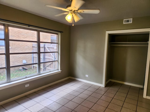 unfurnished bedroom featuring light tile patterned floors, a closet, and ceiling fan