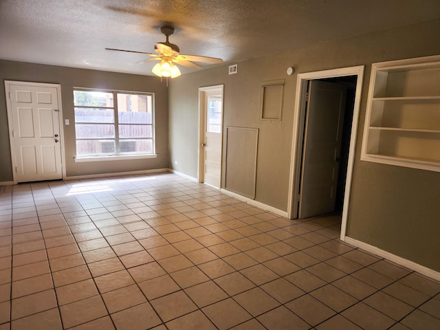 tiled foyer entrance with ceiling fan and a textured ceiling