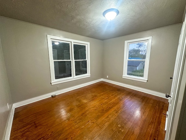 unfurnished room with hardwood / wood-style floors and a textured ceiling