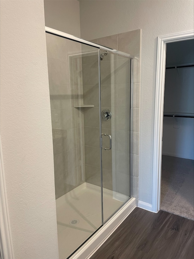 bathroom with wood-type flooring and walk in shower