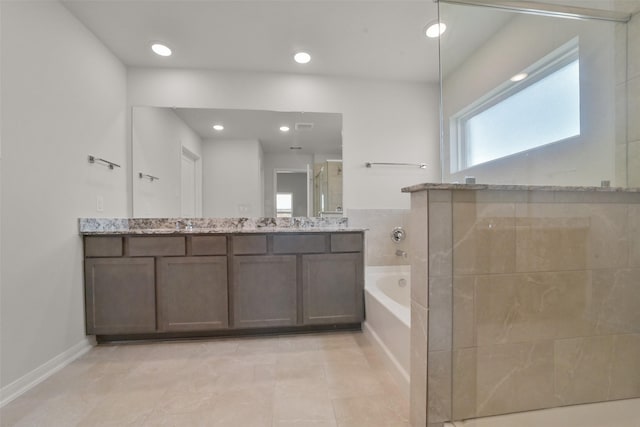 bathroom with tile patterned floors, vanity, and shower with separate bathtub