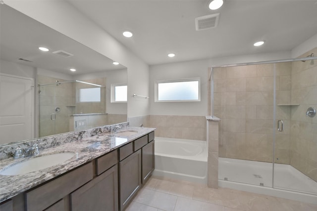 bathroom featuring tile patterned flooring, vanity, and plus walk in shower