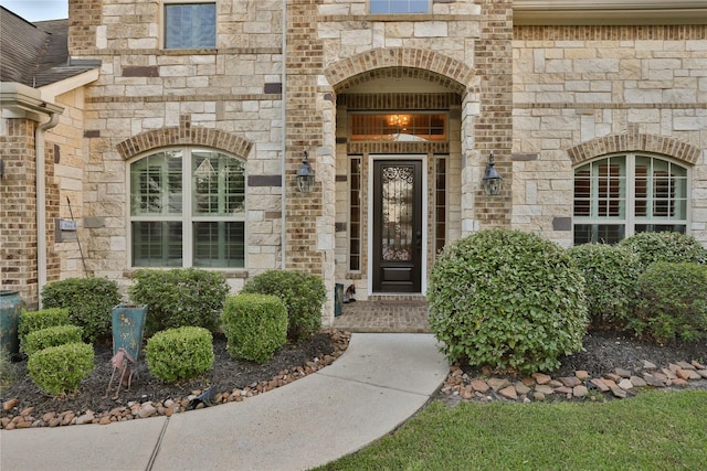 doorway to property featuring stone siding and brick siding