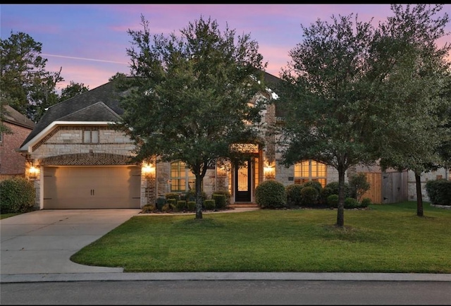 view of property hidden behind natural elements featuring a garage, stone siding, a yard, and concrete driveway