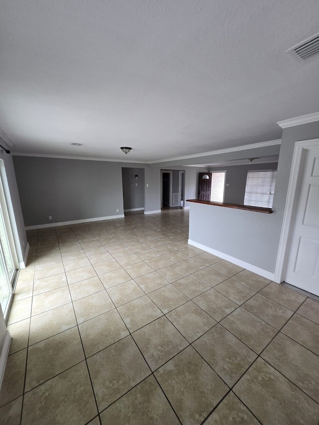 unfurnished room featuring plenty of natural light, light tile patterned flooring, and ornamental molding