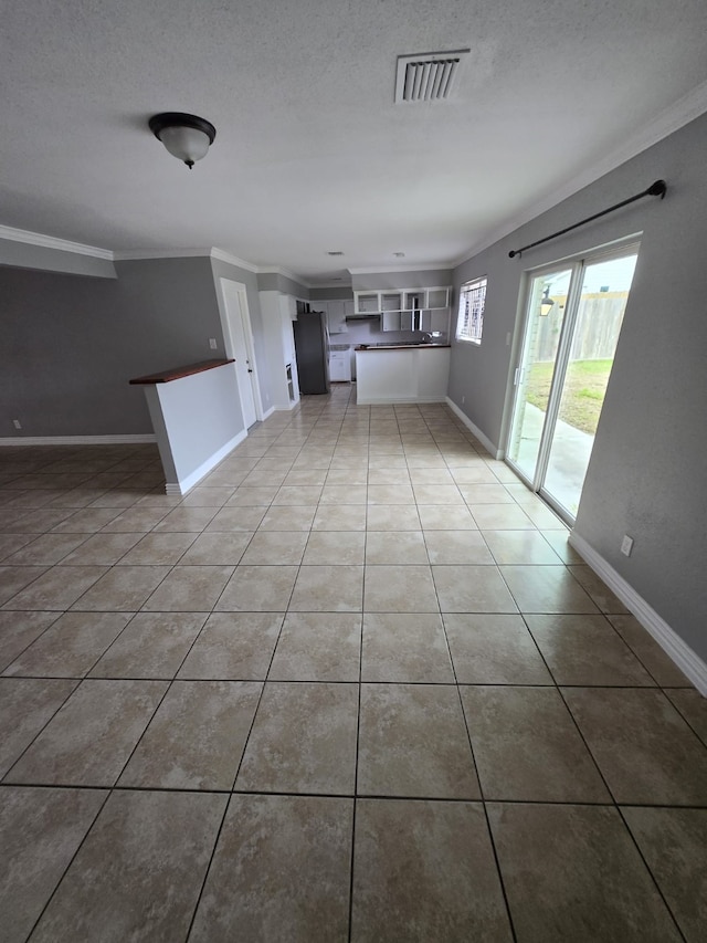 unfurnished living room featuring tile patterned flooring, a textured ceiling, and ornamental molding