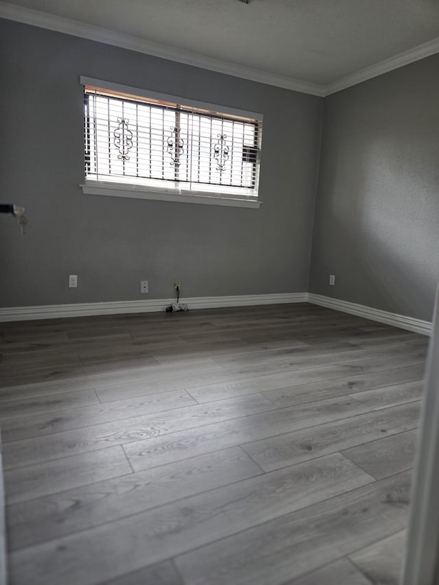 spare room featuring hardwood / wood-style floors, plenty of natural light, and ornamental molding