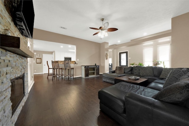 living room with ceiling fan, dark hardwood / wood-style flooring, and a fireplace