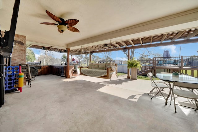 view of patio with ceiling fan and a hot tub