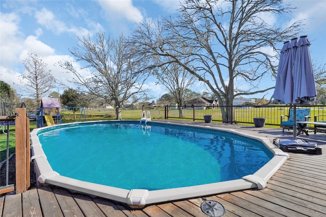 view of swimming pool featuring a deck and a playground