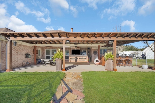 back of house with ceiling fan, a pergola, a lawn, and a patio