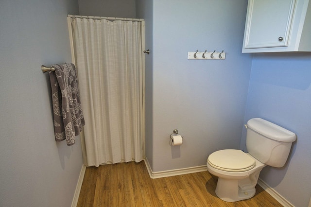 bathroom featuring hardwood / wood-style flooring and toilet