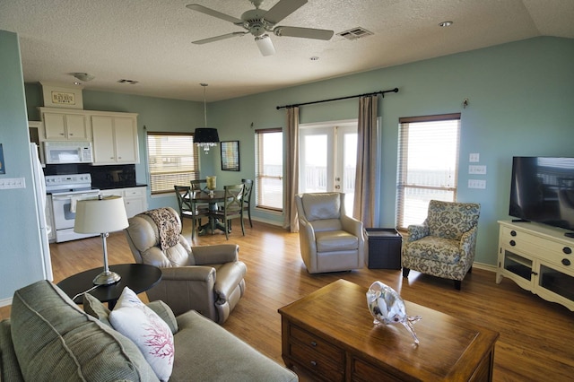 living room with ceiling fan, light hardwood / wood-style floors, and a wealth of natural light