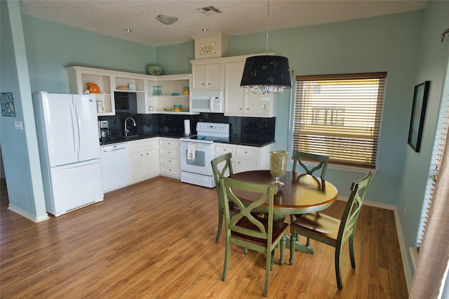 kitchen with sink, tasteful backsplash, a textured ceiling, white appliances, and light wood-type flooring