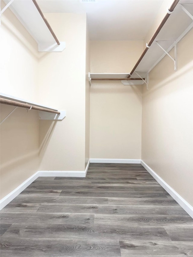 walk in closet with dark hardwood / wood-style flooring