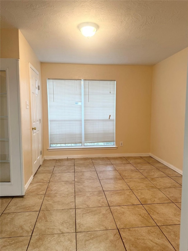 tiled spare room with a textured ceiling