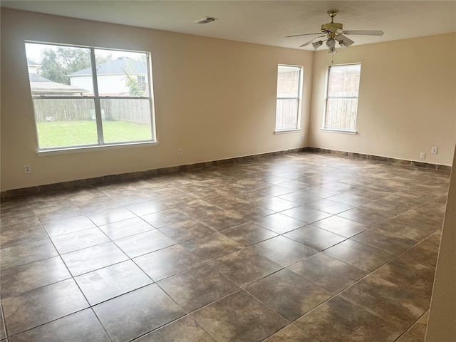 tiled spare room with ceiling fan