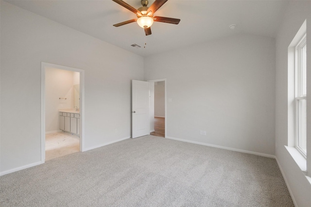 unfurnished bedroom featuring ceiling fan, light carpet, and connected bathroom