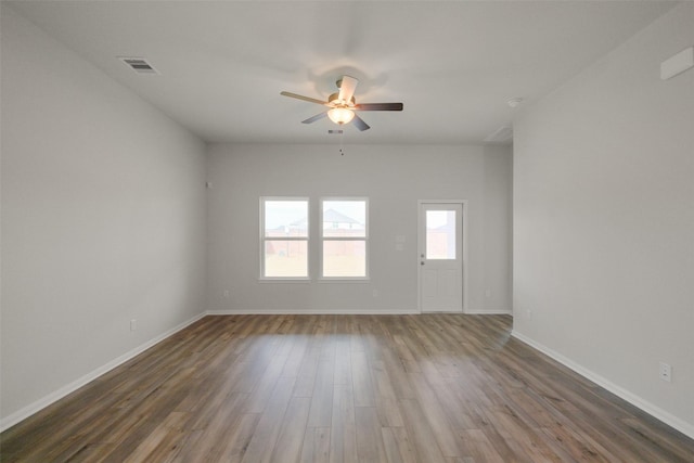 empty room with ceiling fan and dark hardwood / wood-style flooring