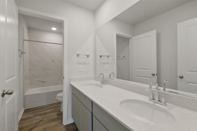 full bathroom with hardwood / wood-style floors, vanity, toilet, and tiled shower / bath combo