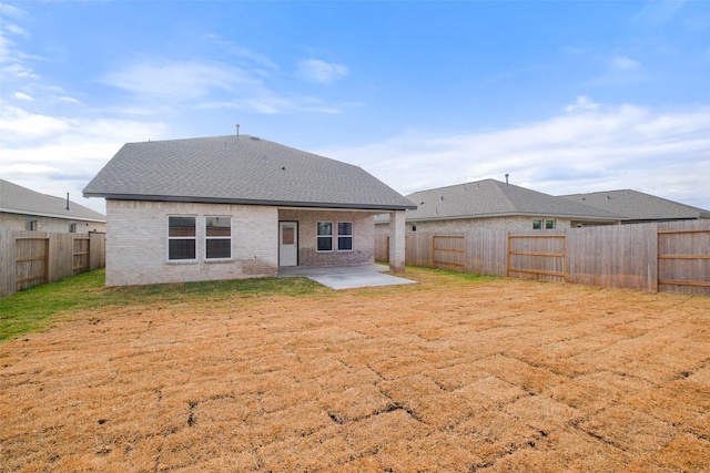 rear view of property with a lawn and a patio