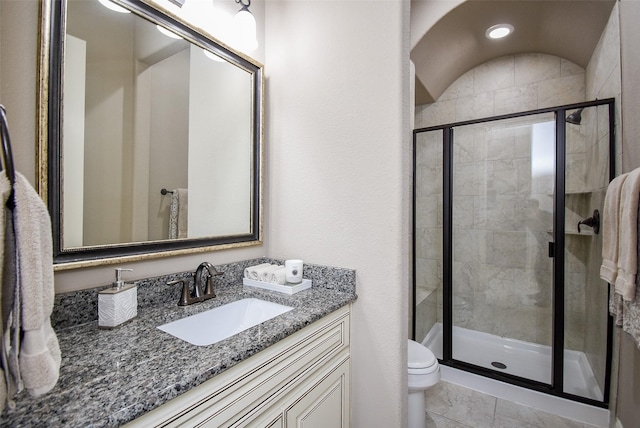 bathroom with vanity, an enclosed shower, and toilet