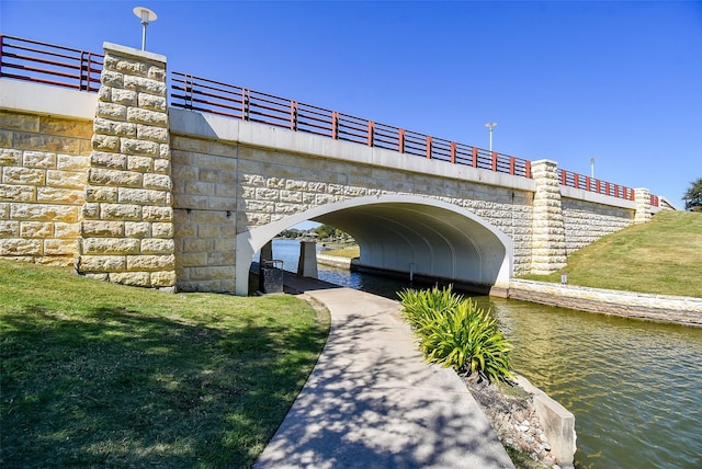 surrounding community featuring a lawn and a water view