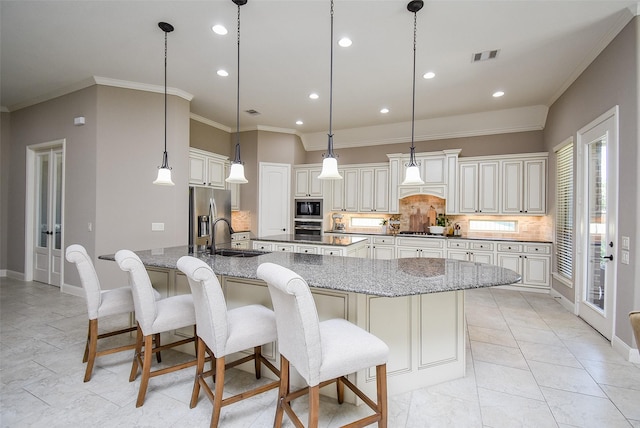 kitchen featuring stone counters, decorative backsplash, stainless steel appliances, and a large island