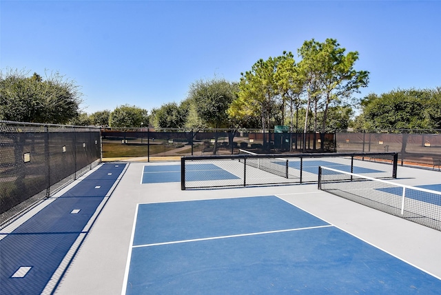 view of tennis court with basketball hoop