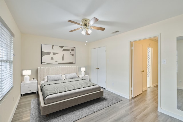 bedroom featuring hardwood / wood-style flooring, ceiling fan, and a closet