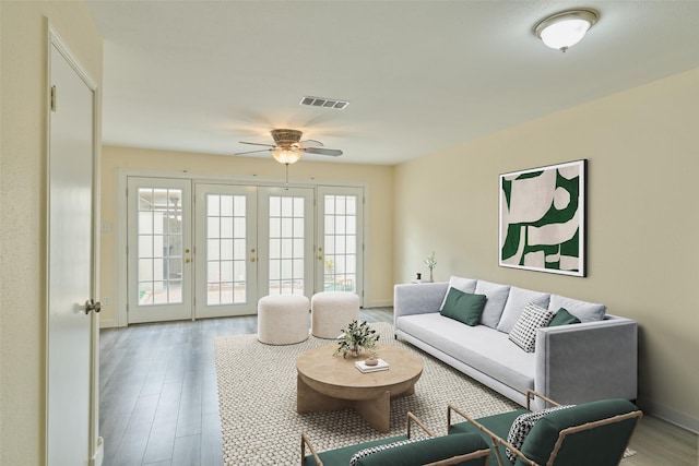 living area with visible vents, baseboards, french doors, wood finished floors, and a ceiling fan