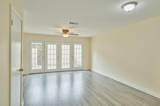 spare room with light wood-type flooring, ceiling fan, and french doors