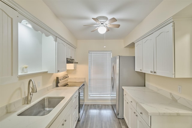 kitchen with sink, white cabinets, ceiling fan, stainless steel appliances, and light wood-type flooring