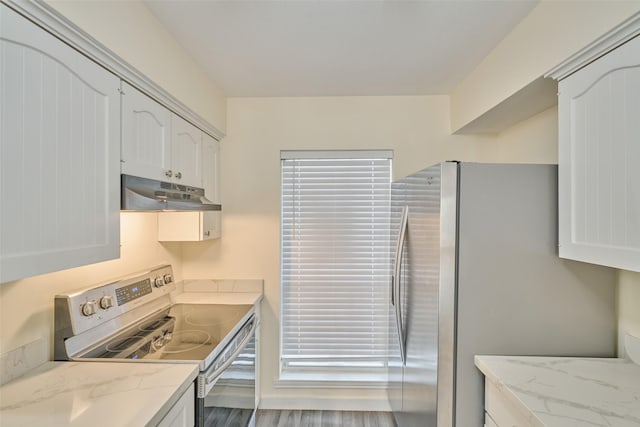 kitchen featuring white cabinetry, stainless steel appliances, wood-type flooring, and light stone counters