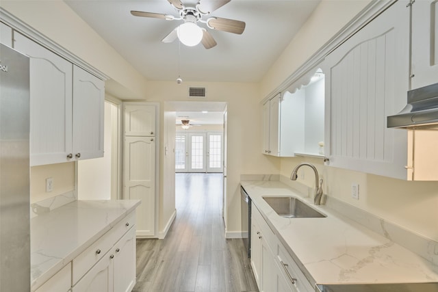 kitchen featuring white cabinetry, light stone countertops, and sink