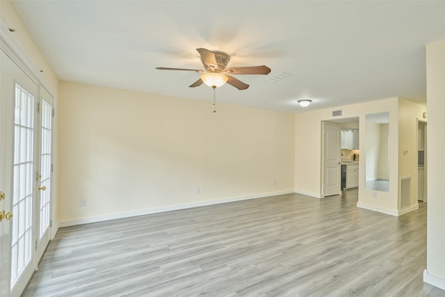 empty room with light hardwood / wood-style flooring, ceiling fan, and french doors