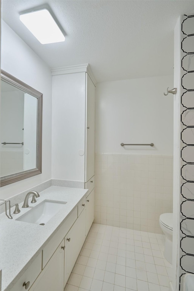 bathroom featuring tile walls, tile patterned flooring, toilet, and a textured ceiling