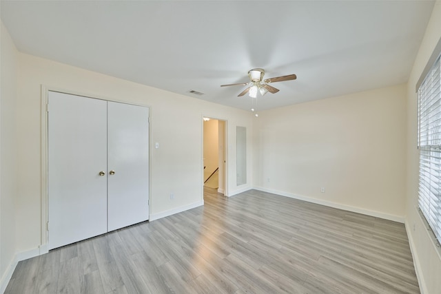 unfurnished bedroom featuring light hardwood / wood-style flooring, a closet, and ceiling fan