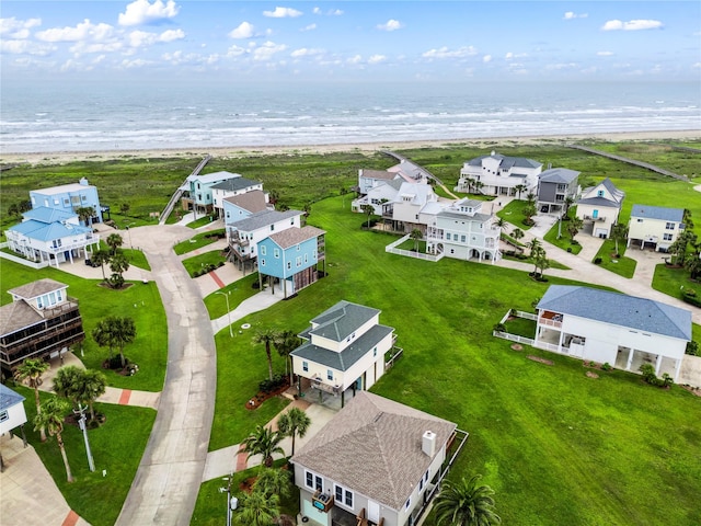 birds eye view of property with a water view and a beach view