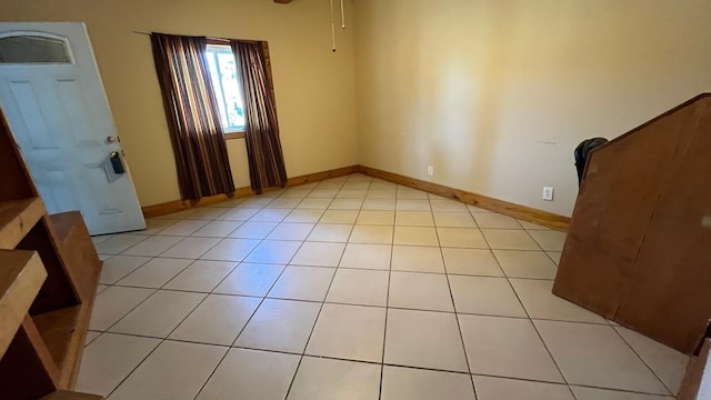 foyer entrance with ceiling fan and light tile patterned flooring