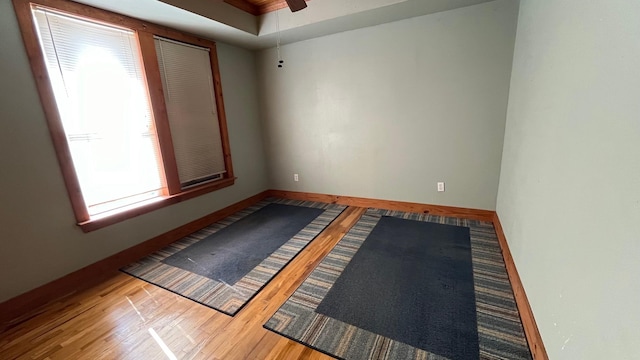 spare room with hardwood / wood-style flooring, ceiling fan, and a healthy amount of sunlight