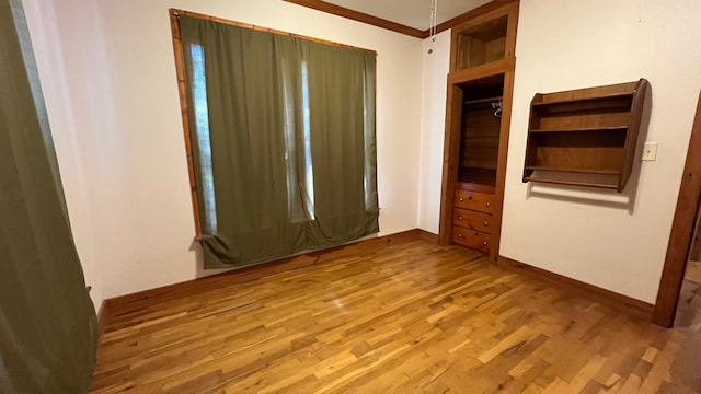 unfurnished bedroom with hardwood / wood-style flooring and crown molding