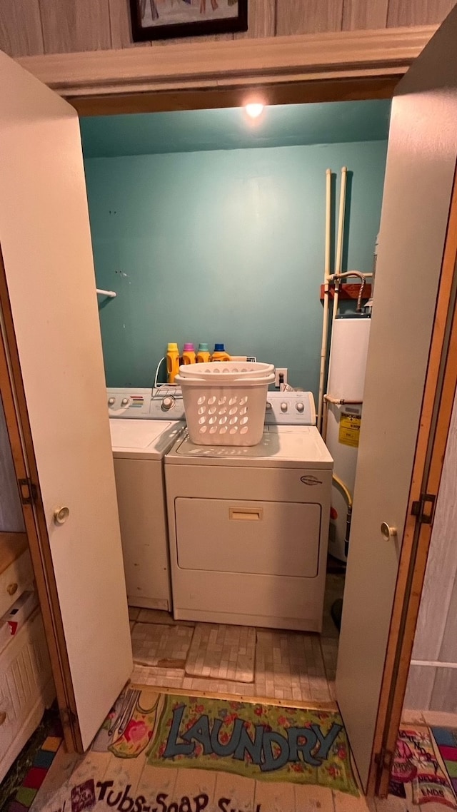 clothes washing area featuring separate washer and dryer and gas water heater