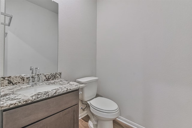 bathroom featuring hardwood / wood-style flooring, vanity, and toilet