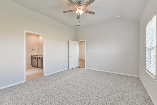 unfurnished bedroom with connected bathroom, ceiling fan, sink, light colored carpet, and lofted ceiling