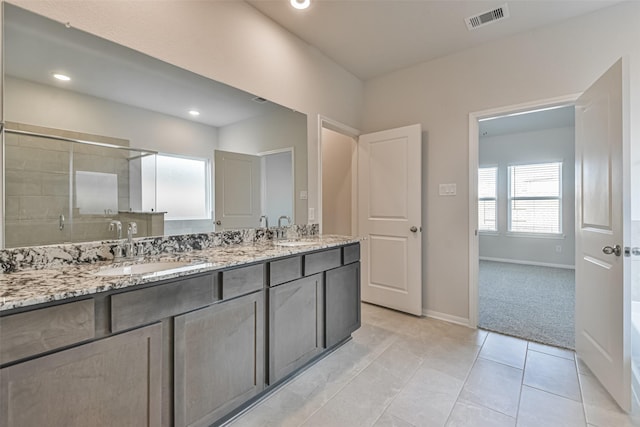 bathroom featuring tile patterned floors, a shower with door, and vanity