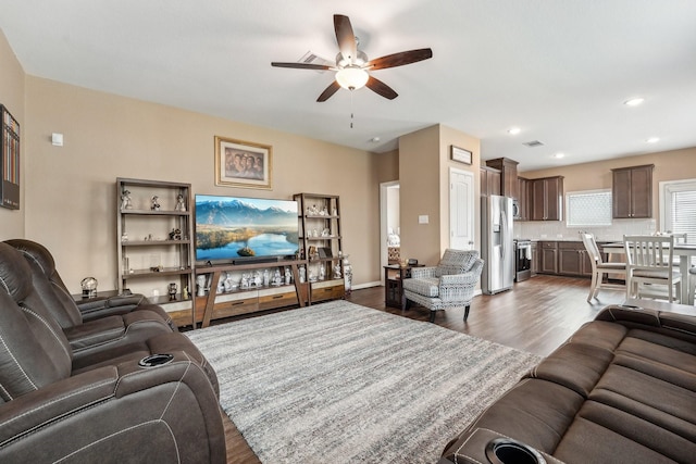 living room featuring ceiling fan and dark hardwood / wood-style flooring