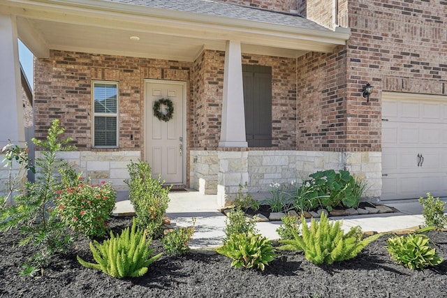 view of exterior entry featuring covered porch and a garage