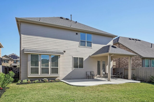 rear view of house with a patio and a lawn