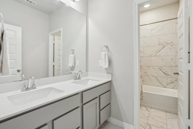 bathroom with tiled shower / bath combo and vanity